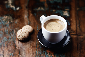 Cup of coffee with Amaretti (Italian biscuits) on rustic wooden background. Copy space.