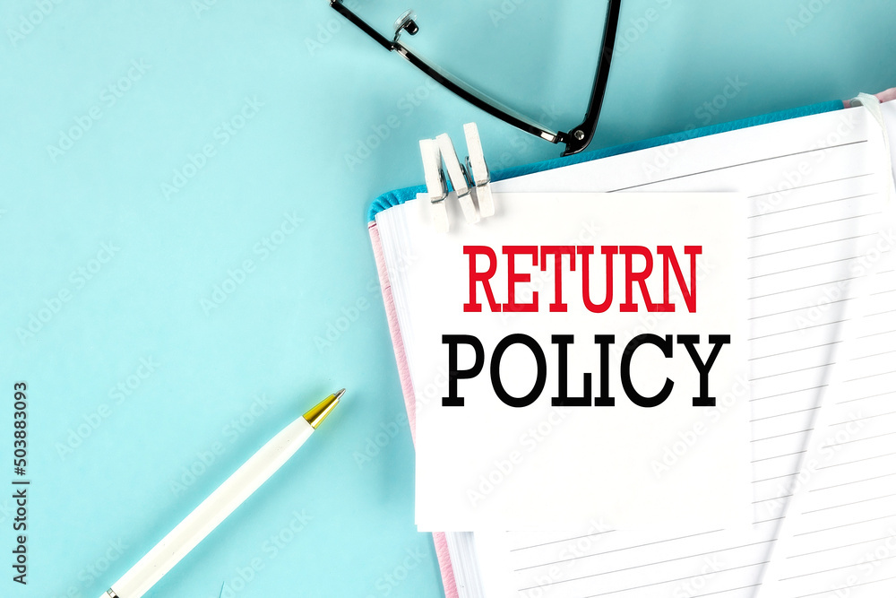 Poster return policy text on a sticky on notebook with pen and glasses , blue background