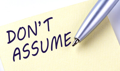 Obraz premium Sticky Note Message Don't Assume with pen on the white background