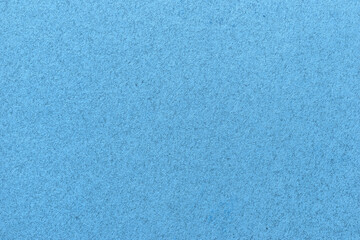 Texture of old light blue paper closeup. Structure of a matte dense sky cardboard wallpaper.