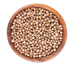Coriander seeds in wooden bowl, isolated on white background. Cilantro grain. Organic spice. Top view.