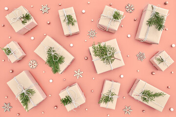 Pattern made of wrapped in craft paper small Christmas gift boxes with natural fir tree branches...
