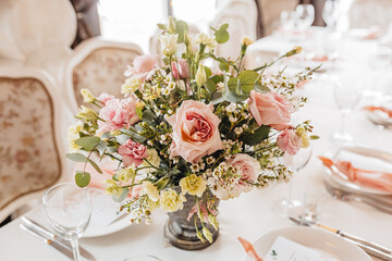 Luxury table setting for dining in a restaurant in pastel colors close up. Wedding party table set for banquet