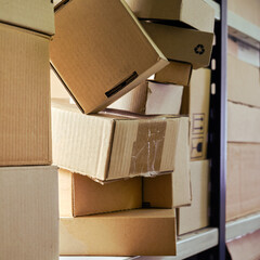Warehouse overflowing with boxes of goods and postal parcels. Cardboard boxes on the shelves of a...
