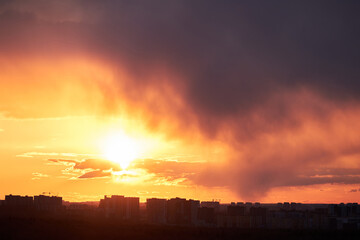 Obraz premium Dark clouds in the evening sunset sky with the setting sun. Dramatic sky during orange sunset