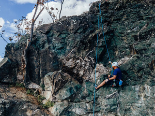 Photo of a professional male climber, climbing on the rock.