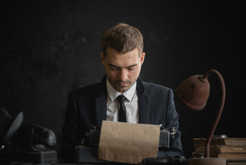 Detective agent is working by the desk and write a report with a typewriter concept.