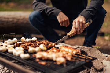 Close up of a male making a barbecue, grilling meat and vegetables.