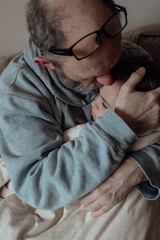 Fototapeta premium Worried middle aged hoary man supporting little frightened grandgirl. Concept of stress and fear