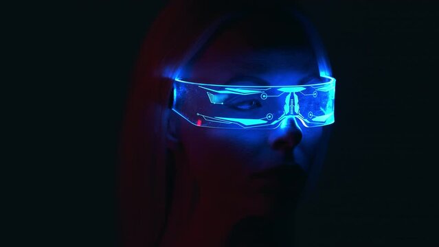 The woman in an interactive glasses in the darkness