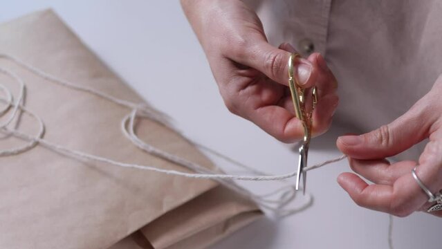 Packaging things in craft eco paper and rope bonding. Preparing for shipment, for sale concept. Close-up 4k, view from above