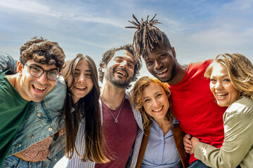 portrait of six people smiling in front of the camera on sunny day, multiracial group of friends...