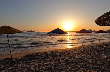 sunset on tropical beach and beach umbrellas