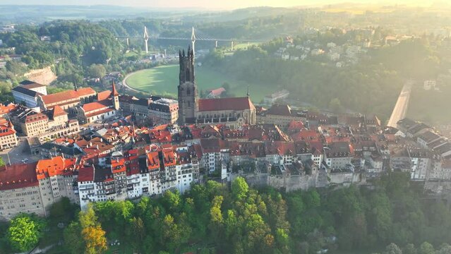 aerial view of historical town of Fribourg in Switzerland on a foggy morning, tourism in Switzerland concept, beautiful Swiss cityscape of medieval town of Fribourg with a church tower and colourful