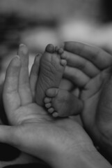 the child's legs. the mother holds the baby's legs. the child's feet in the palms