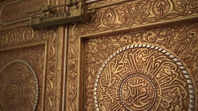 Close up. Tilt-up of replica beautiful ornate copper and silver Kaaba doors inside Mosque.