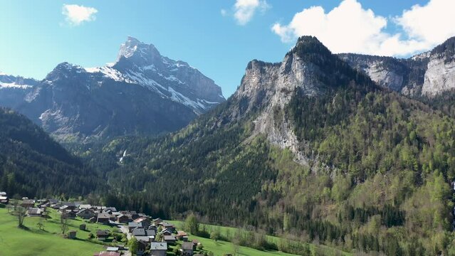 Stunning drone footage of Alpine Mountains, forests and waterfalls. Chalets nestle in the beautiful landscape near Sixt fer Cheval in the French alps.