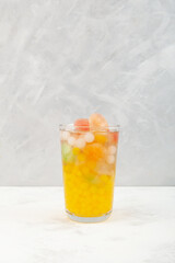 Boba drink or fruits bubble tea. Refreshing  cocktail with fruits ice cubes on grey textured background. Selective focus, copy space