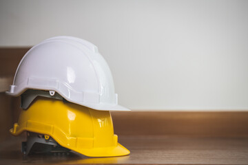 engineer safety helmet white and yellow placed on wooden floor.