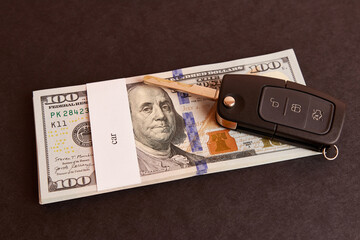 Naklejka premium Bundle of dollars with the inscription car and car keys on a black background. Car buying concept.