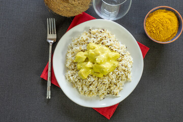 top view of chicken in coconut milk and curry with rice on a plate
