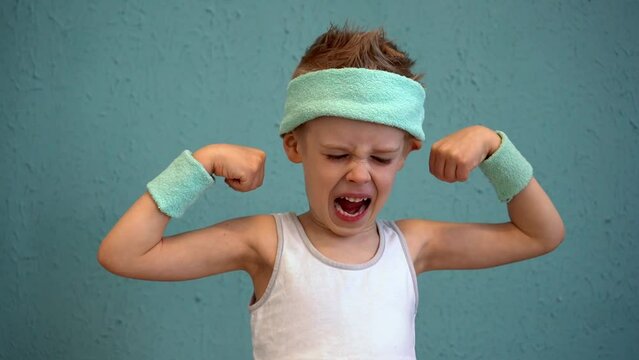 Sports boy shows muscle strength. Children's fitness