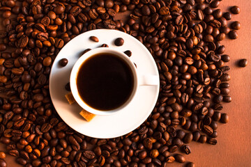 White porcelain espresso coffee cup with saucer on brown background.