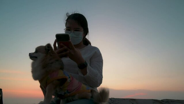 Asian young woman wearing a hygiene protective mask over her face at the beach with sunset,Coronavirus Covid-19 and Air pollution pm2.5 concept travel	
