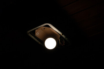 Tungsten light bulb lit on black background