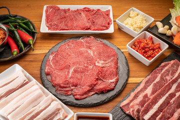 Mixed fresh Beef and pork belly set for BBQ grilling with Kimchi, fresh vegetables, fresh chili and dipping sauce, Korean BBQ.