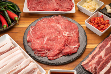 Mixed fresh Beef and pork belly set for BBQ grilling with Kimchi, fresh vegetables, fresh chili and dipping sauce, Korean BBQ.