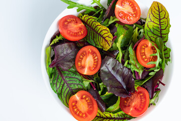 healthy food. fresh salad with salmon, spinach, cherry tomatoes, red onion and basil in marble plate with fork on white marble table. close up