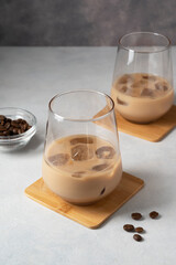 Irish cream liqueur in two glasses with ice cubes and coffee beans