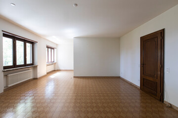 Obraz premium Large lounge with white walls and brown tiled floor. Interior vintage abandoned villa ready to be demolished