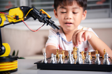 Asian little boy is playing chess with robot machine arm, STEM education E-learning, Funny children...
