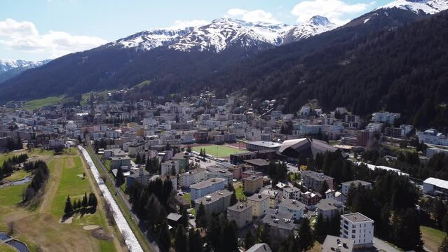 Wide aerial panorama of Davos city with the Congress Centre and snowy peaks.