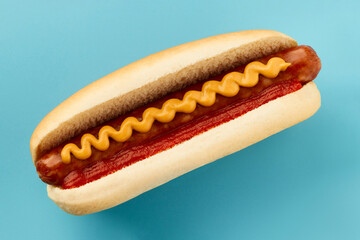 Classic hot dog with wurst, ketchup and mustard on blue background. Menu for restaurant