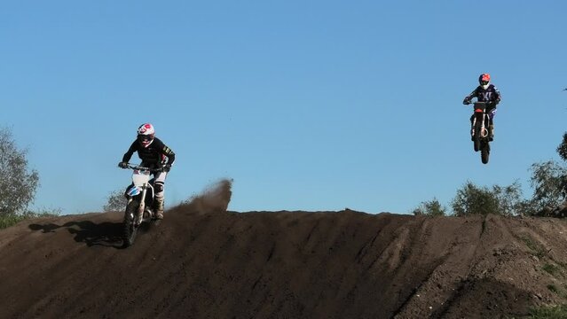 Dirt bikes jumping on motocross circuit in Arnhem, the Netherlands, with visiible hill