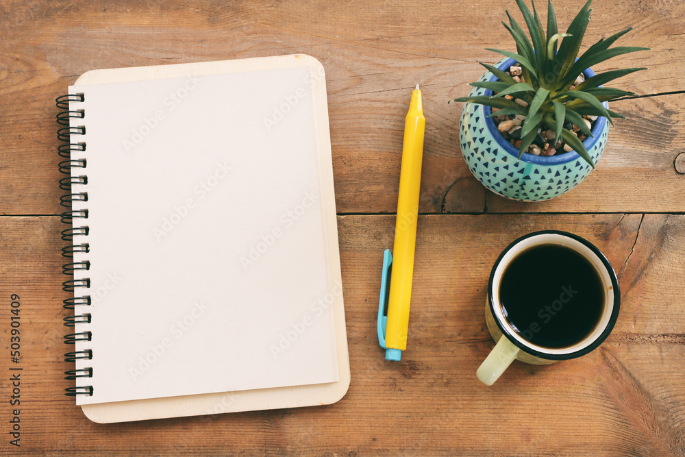 Fototapete top view image of open notebook with blank pages and cup of coffee over wooden desk. ready for addin