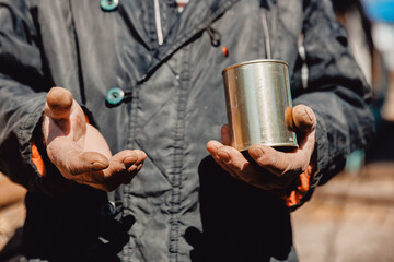 Dirty hands homeless old poor man with canned food donation. Concept global crisis, economic recession