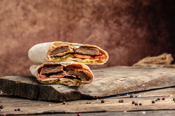 Kebab, pita, gyros, shaurma, wrap sandwich stuffed with cutlet from minced meat, french fries, fresh vegetables, sauce. Street food. Takeaway food.