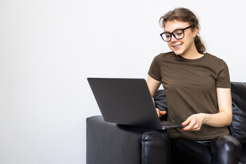 Young woman using a laptop while relaxing on the couch