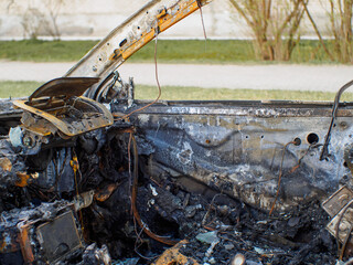 Car interior after fire. Selective focus on burned side door.