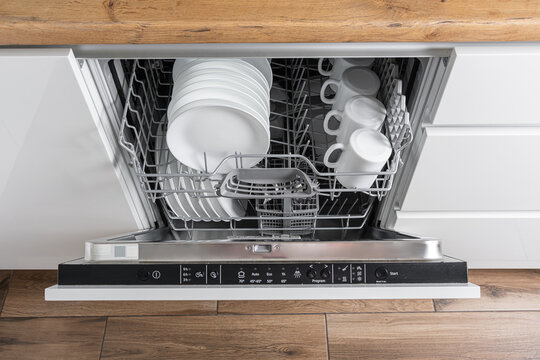 Dishwasher with clean dishes in a white kitchen