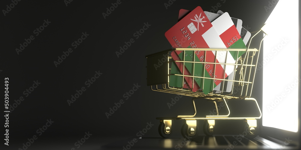 Aufkleber credit card mockups with flags of oman in a small shopping cart on the laptop. 3d rendering