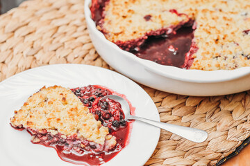 a piece of berry pie with crunchy top. usingfresh summer berries for baking. easy recipe. cobbler made of blueberry and cranberry.