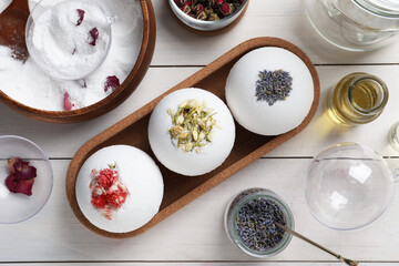 Flat lay composition with bath bombs and ingredients on white wooden table