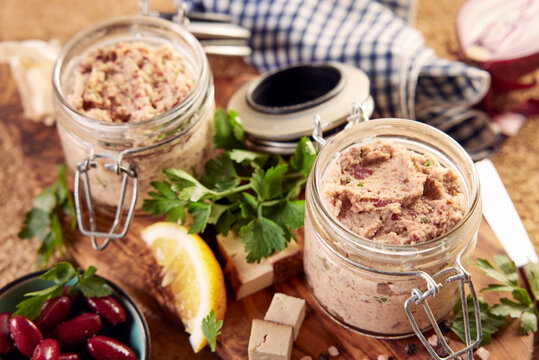 Jars with vegan liverwurst pate served on table with fresh ingredients