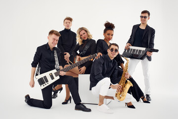 Portrait of diverse group of young people musical band playing with instruments - isolated on white background.