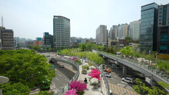 The Seoullo 7017 skygarden with pedestrians, trees and flowers on an elevated, linear park above the highway